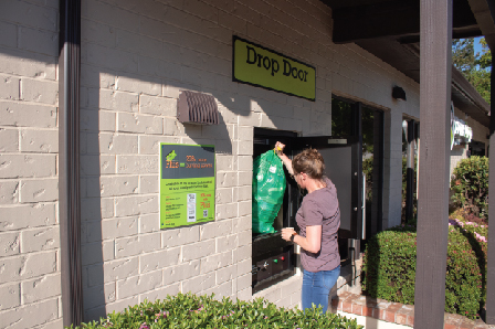 Person dropping off a Green Bag in a BottleDrop Redemption Center drop door