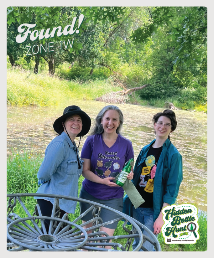 Photo of three adults who found the shiny green commemorative bottle.